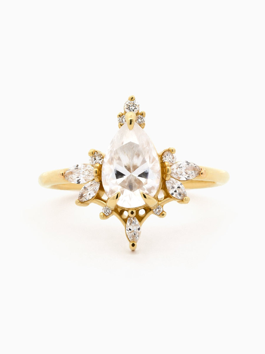 Gold ring with a large central gemstone and smaller stones on a white background