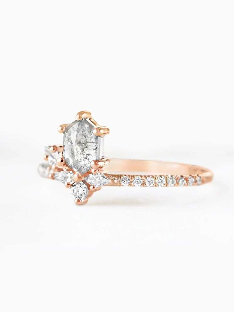 Rose gold ring with a pear-shaped diamond on a white background