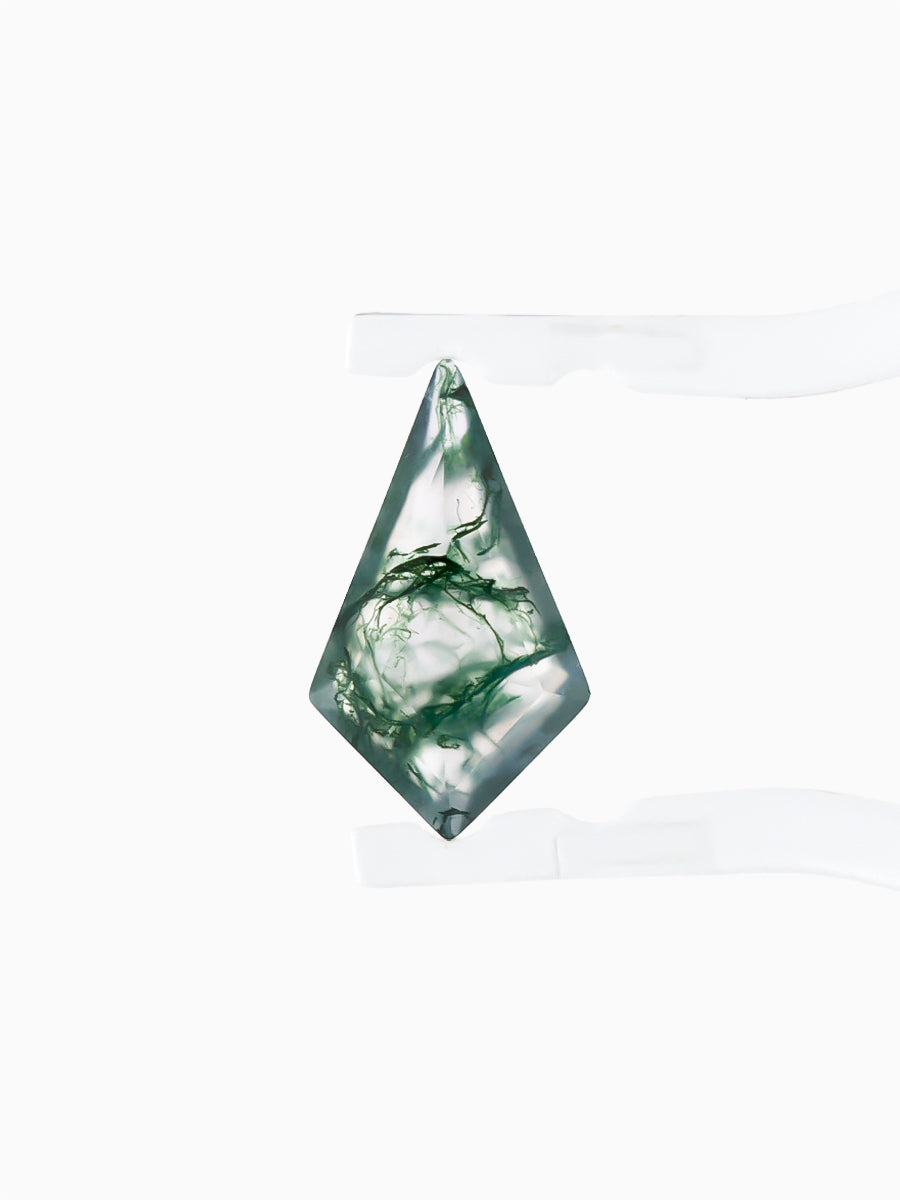 Kite-shaped loose moss agate gemstone with dendritic green inclusions held by tweezers, face view