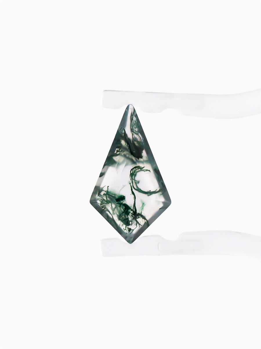 Kite-shaped loose moss agate gemstone with dendritic green inclusions held by tweezers, face view