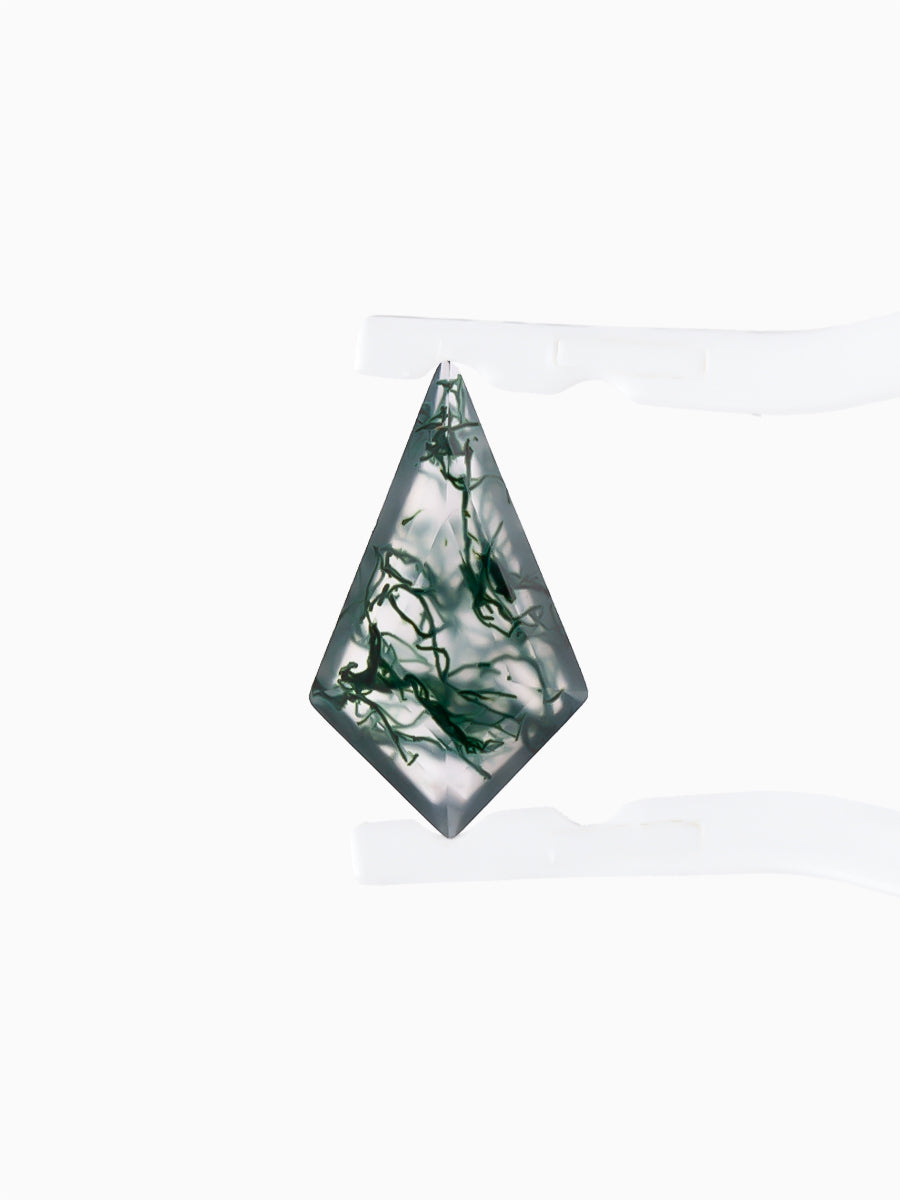 Kite-shaped loose moss agate gemstone with dendritic green inclusions held by tweezers, face view