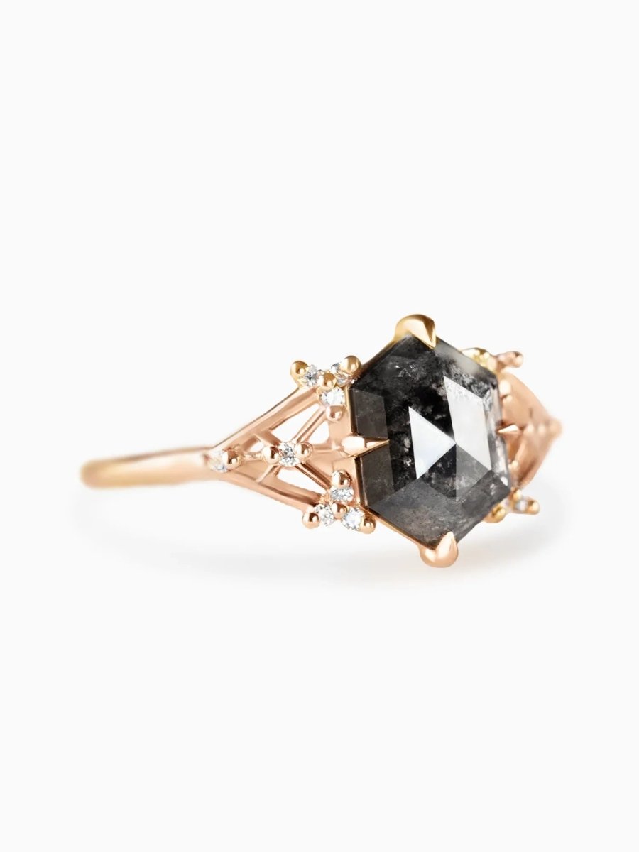Rose gold ring with a black diamond on a white background