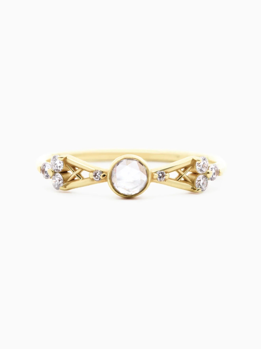 Face view of petite contemporary Art Deco yellow gold ring with open-back bezel-set round diamond, tapered lattice shank, and trefoil clusters