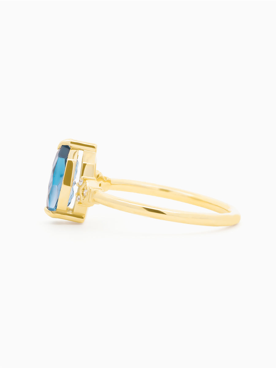 Gold ring with a blue starbrite sapphire on a white background. profile view to show floating setting