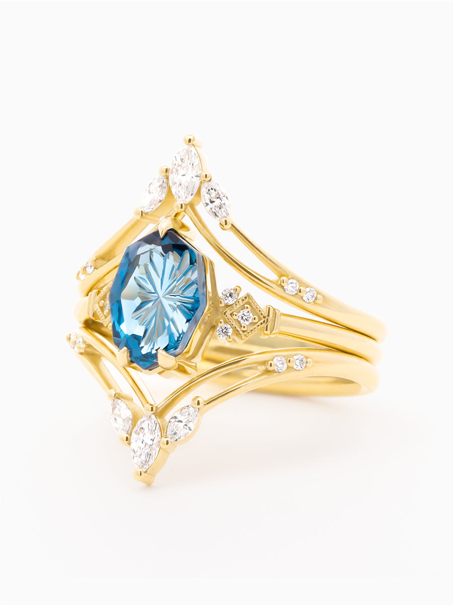 Gold ring with a blue gemstone and diamond accents on a white background