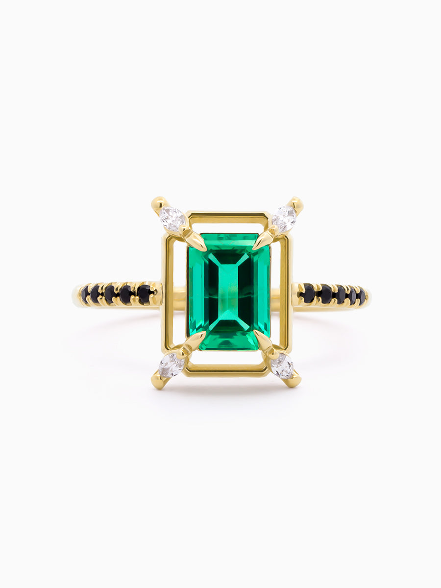 Verdant Ring face view with emerald-cut emerald, geometric halo, and marquise corner accents on white background