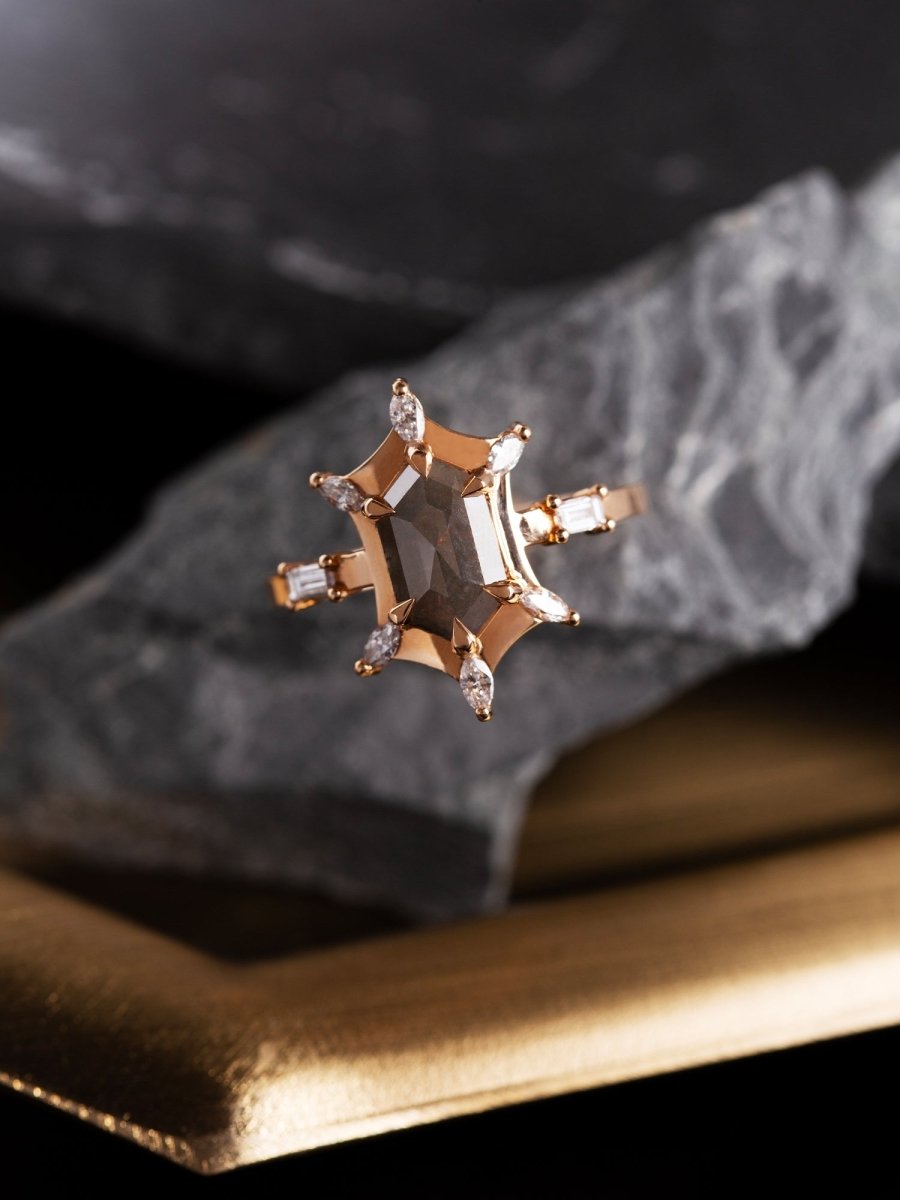 Gold ring with central diamond and smaller stones on a textured surface