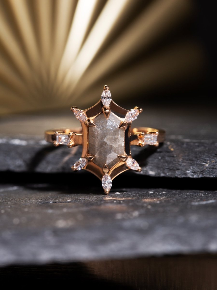 Gold ring with star-shaped diamond on a dark surface