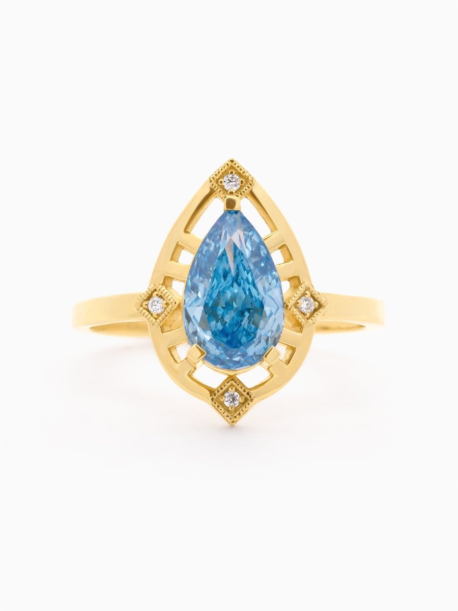  face view of ring with pear-cut blue diamond centered above a golden open halo with radiating trusses
