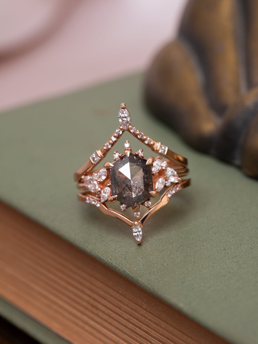 Rose gold ring with a central diamond on a green surface