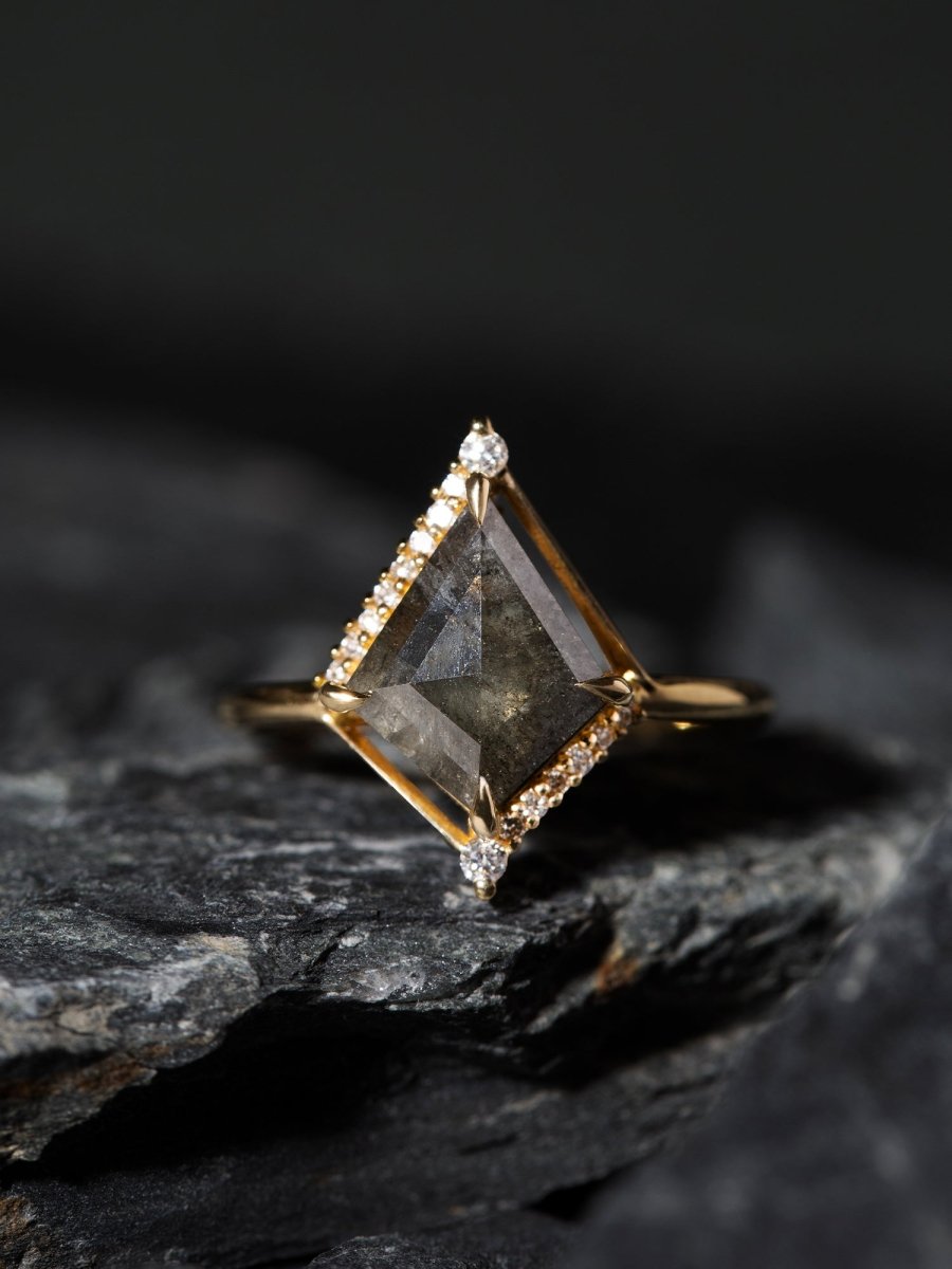 Gold ring with a large diamond on a dark stone surface