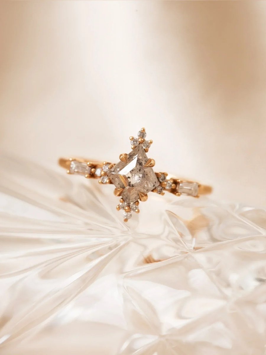 Rose gold ring with diamond accents on a soft beige fabric background