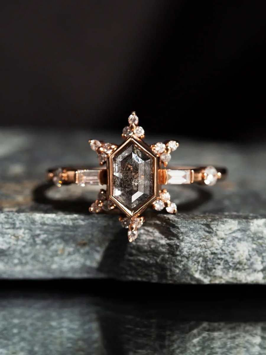 Rose gold ring with a star-shaped diamond on a dark background