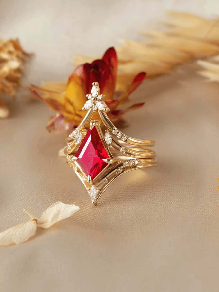 Gold ring with a red gemstone on a beige background