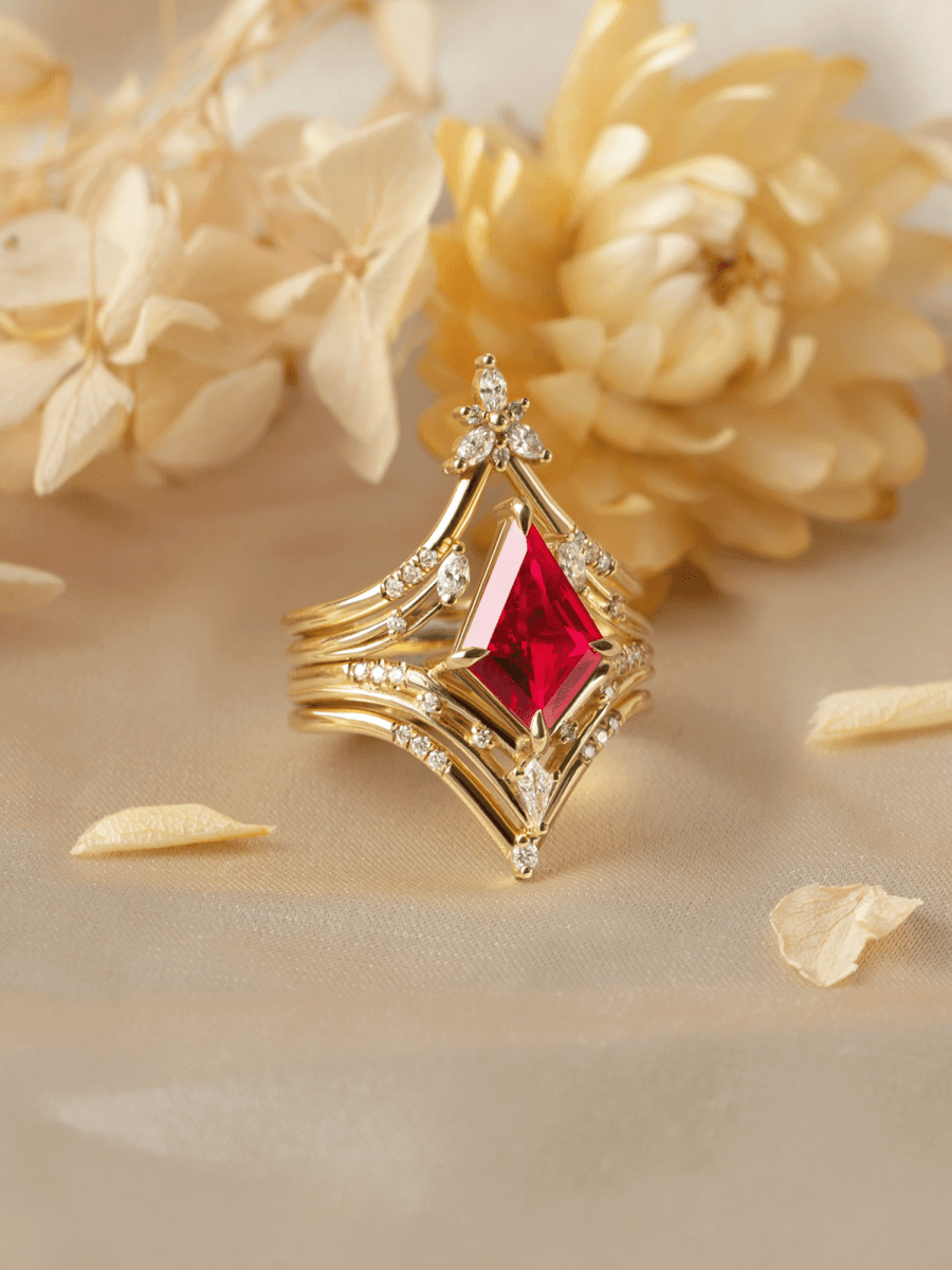 Gold ring with a red gemstone on a beige background with flowers