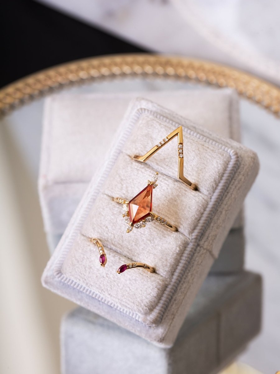 Set of gold rings with gemstones on a white jewelry box