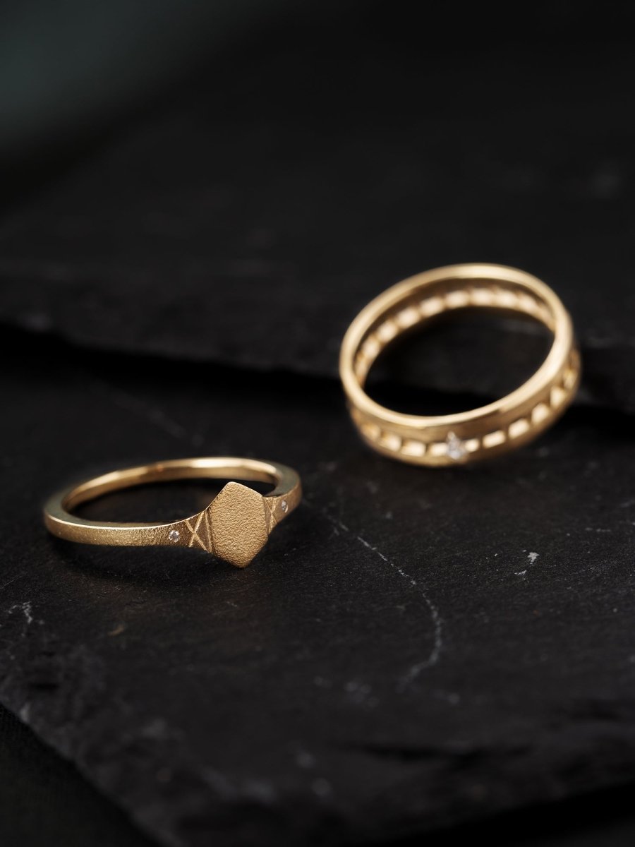 Two gold rings on a dark textured surface