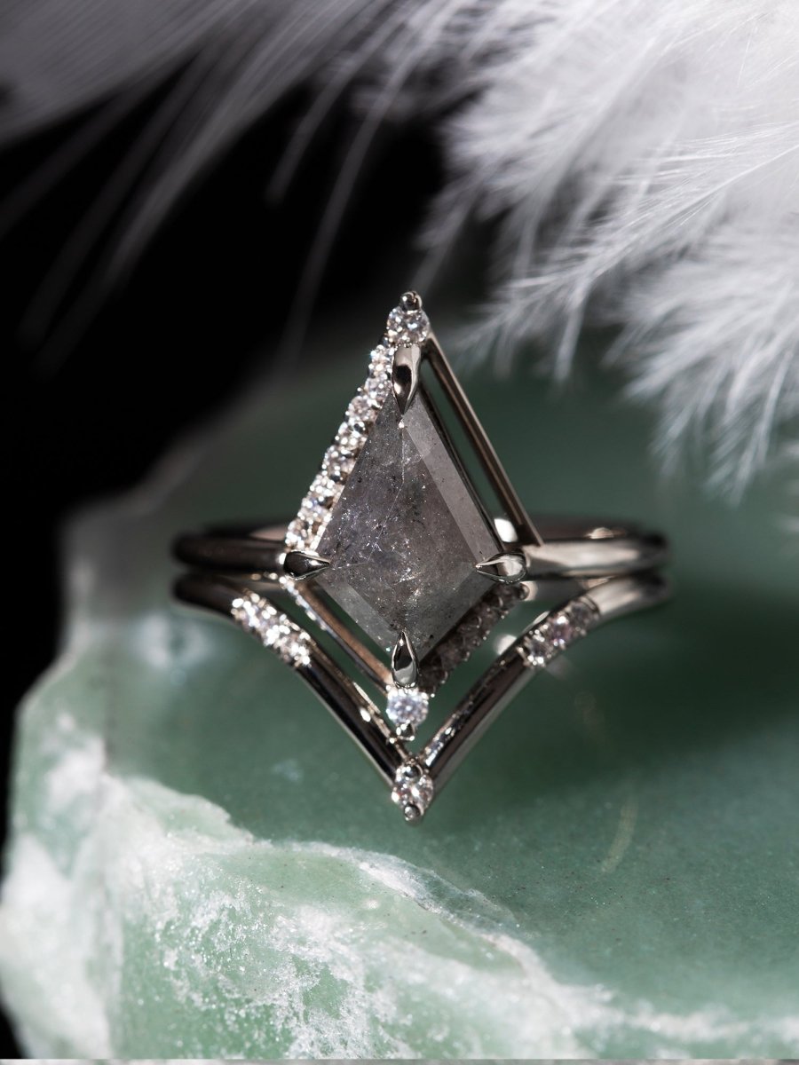 Silver ring with a large diamond and smaller diamonds on a textured surface