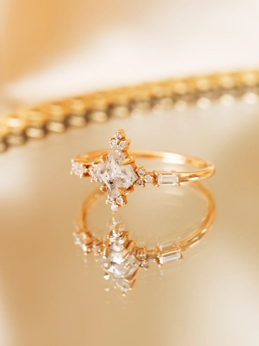 Gold ring with diamond accents on a reflective gold surface