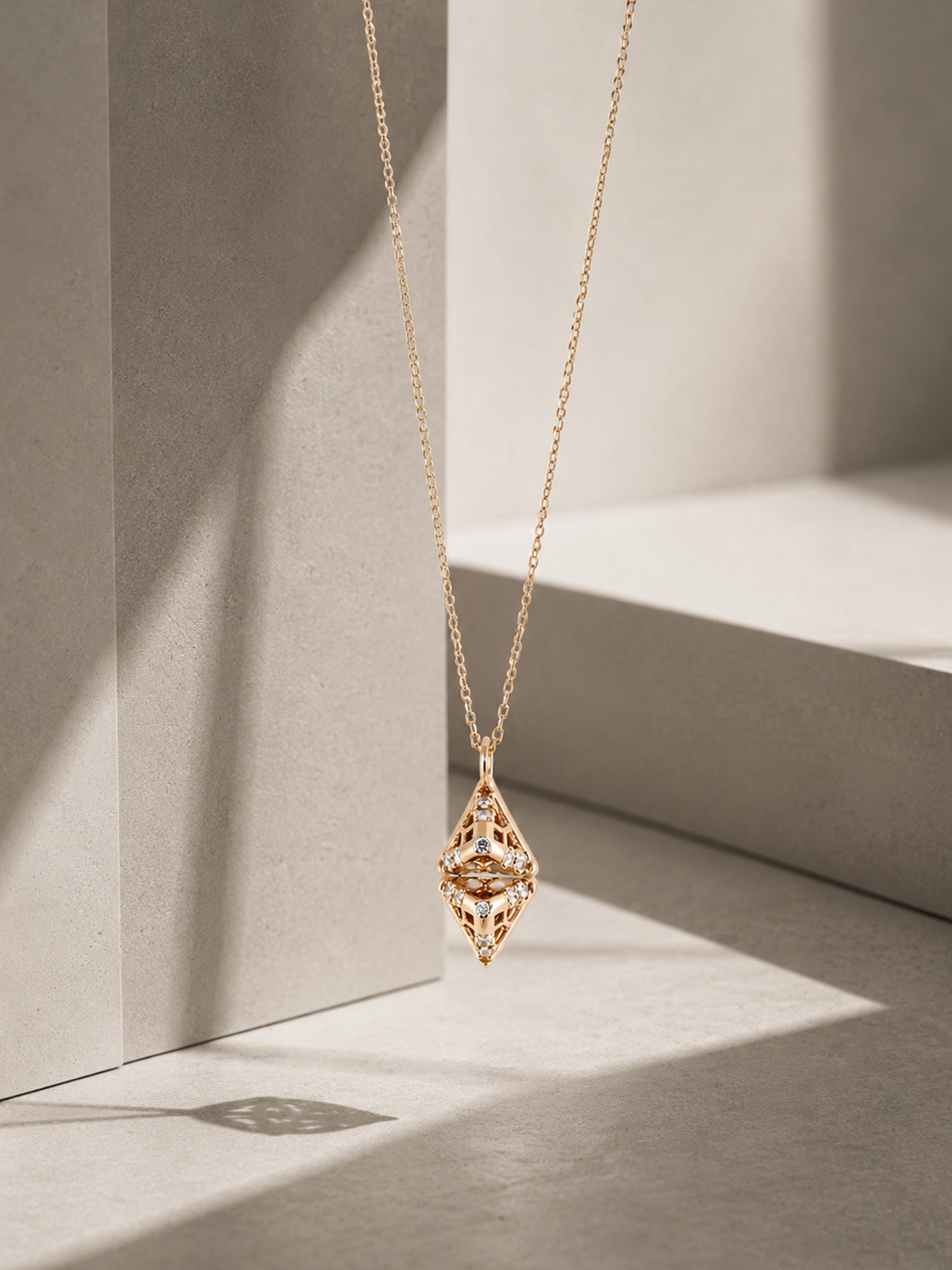 Gold necklace with a pendant on a light gray background