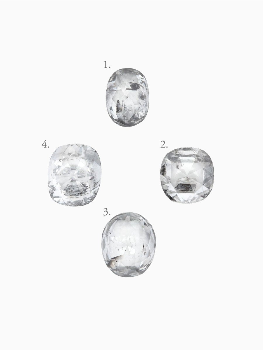 Five clear cushion salt pepper diamonds of varying sizes on a white background