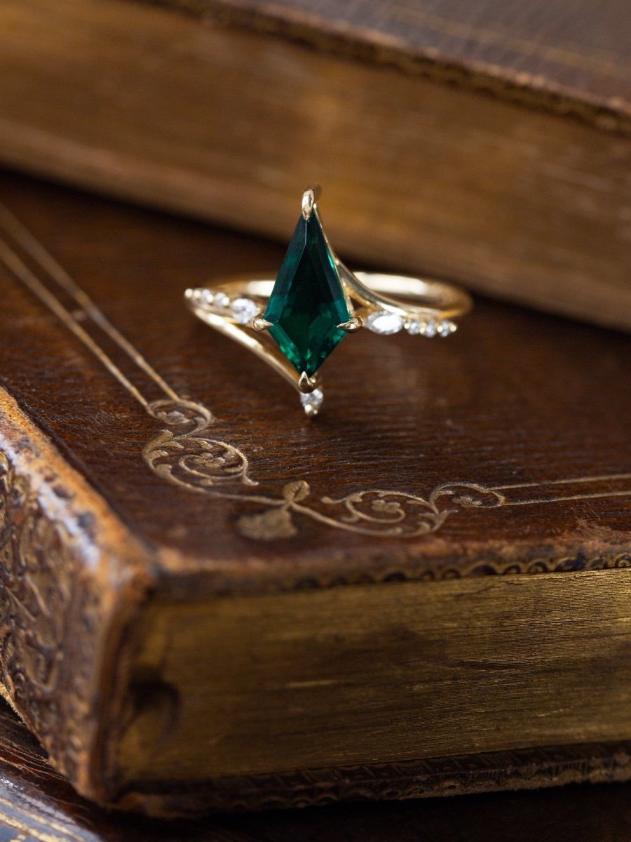 Gold ring with a green gemstone on an old book
