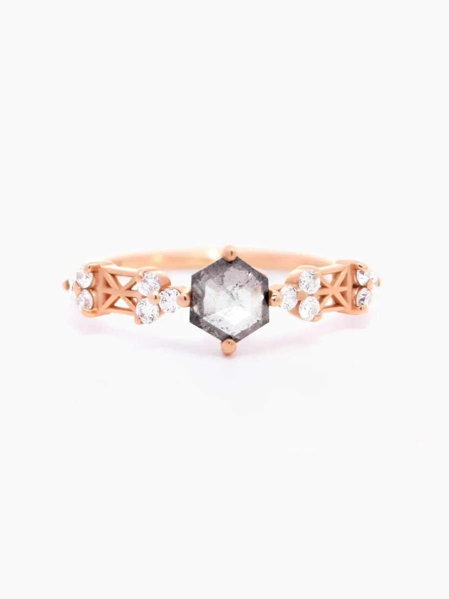 Face of a Modern Art Deco engagement ring featuring a salt and pepper hexagon diamond center, round trefoil clusters, and architectural latticework