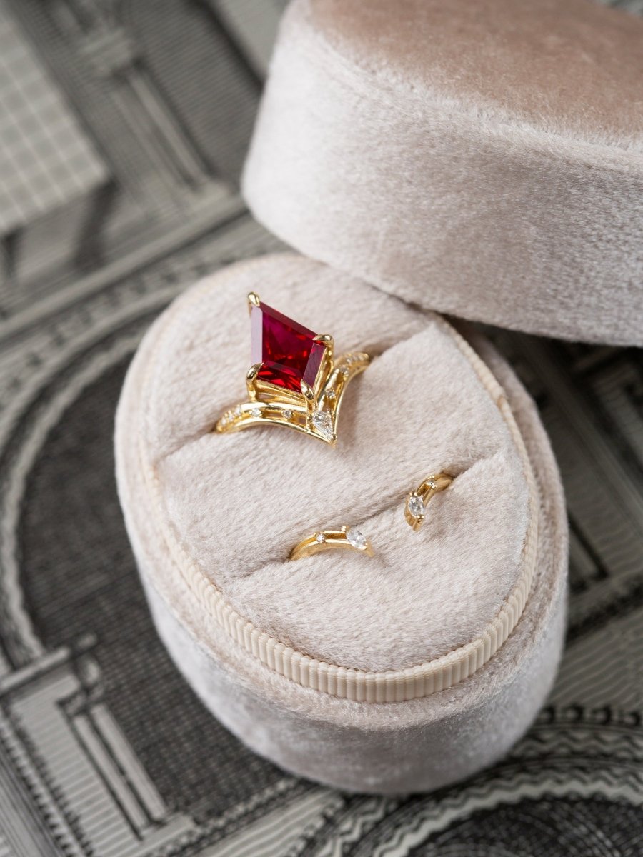 Gold ring with a red gemstone in a jewelry box on a blurred architectural background