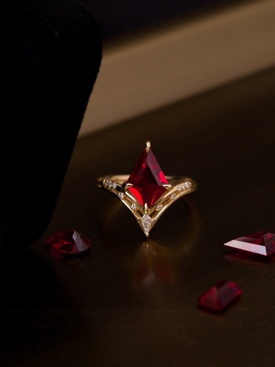 Gold ring with a red gemstone on a dark surface