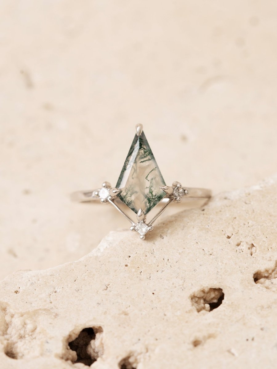Ring with a triangular gemstone on a sandy background