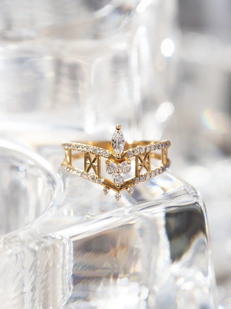 Gold and diamond ring on a clear glass surface with blurred background