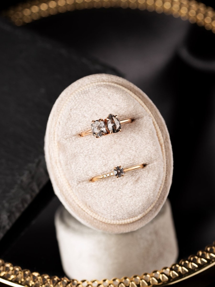 Two rings on a beige cushion with a blurred background