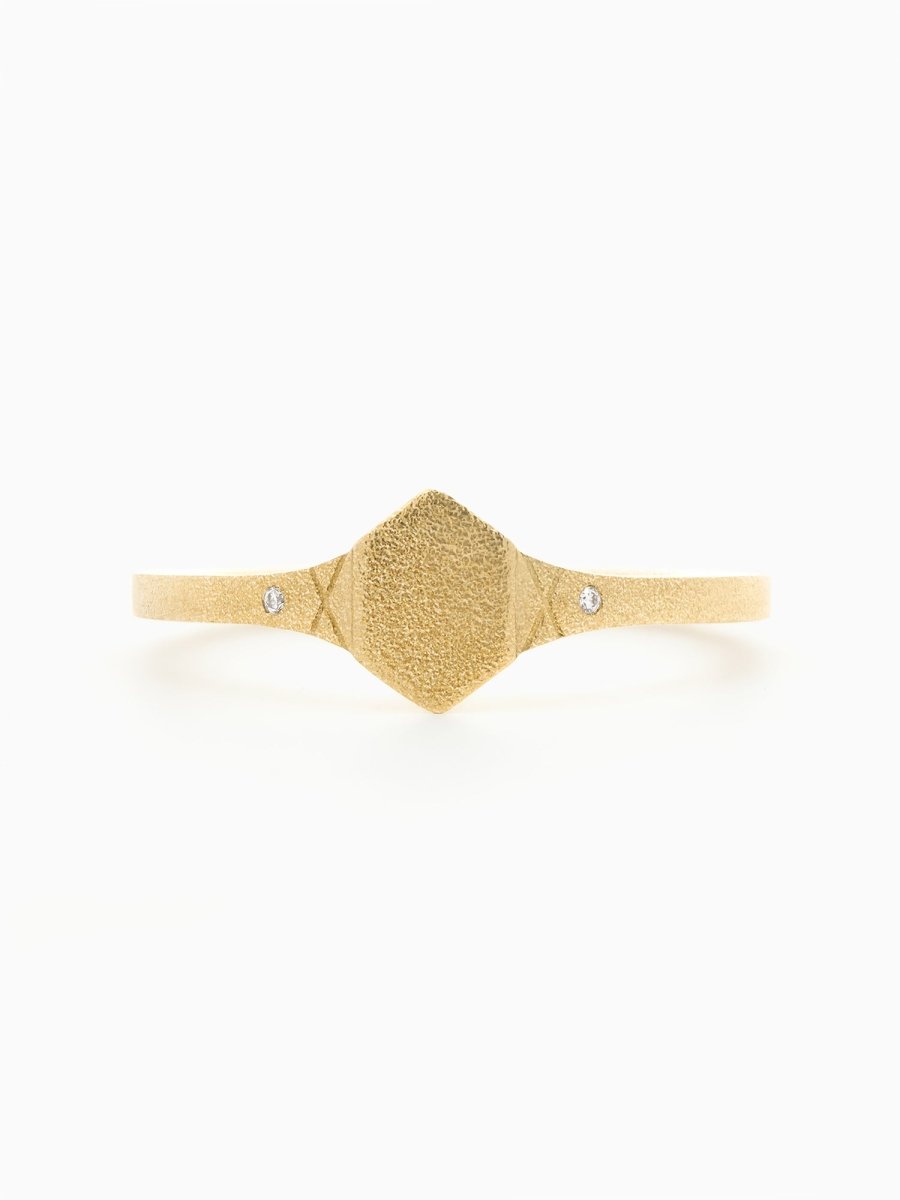 Hexagon signet ring face with petite round diamond on shoulder and engraved X details.