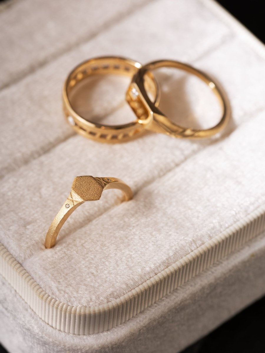 Three gold rings on a textured surface