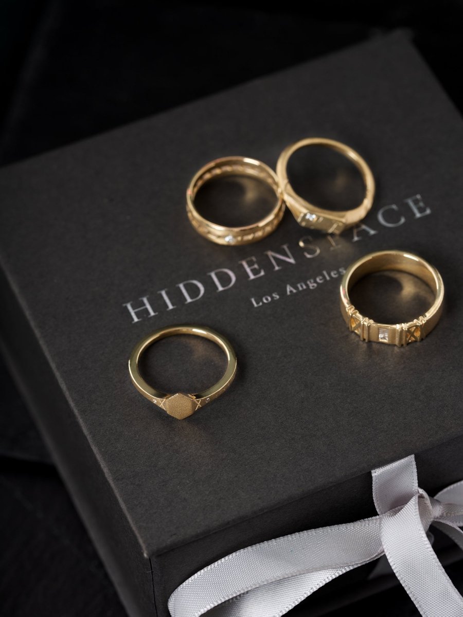 Gold rings on a black box with 'Hiddenspace' branding