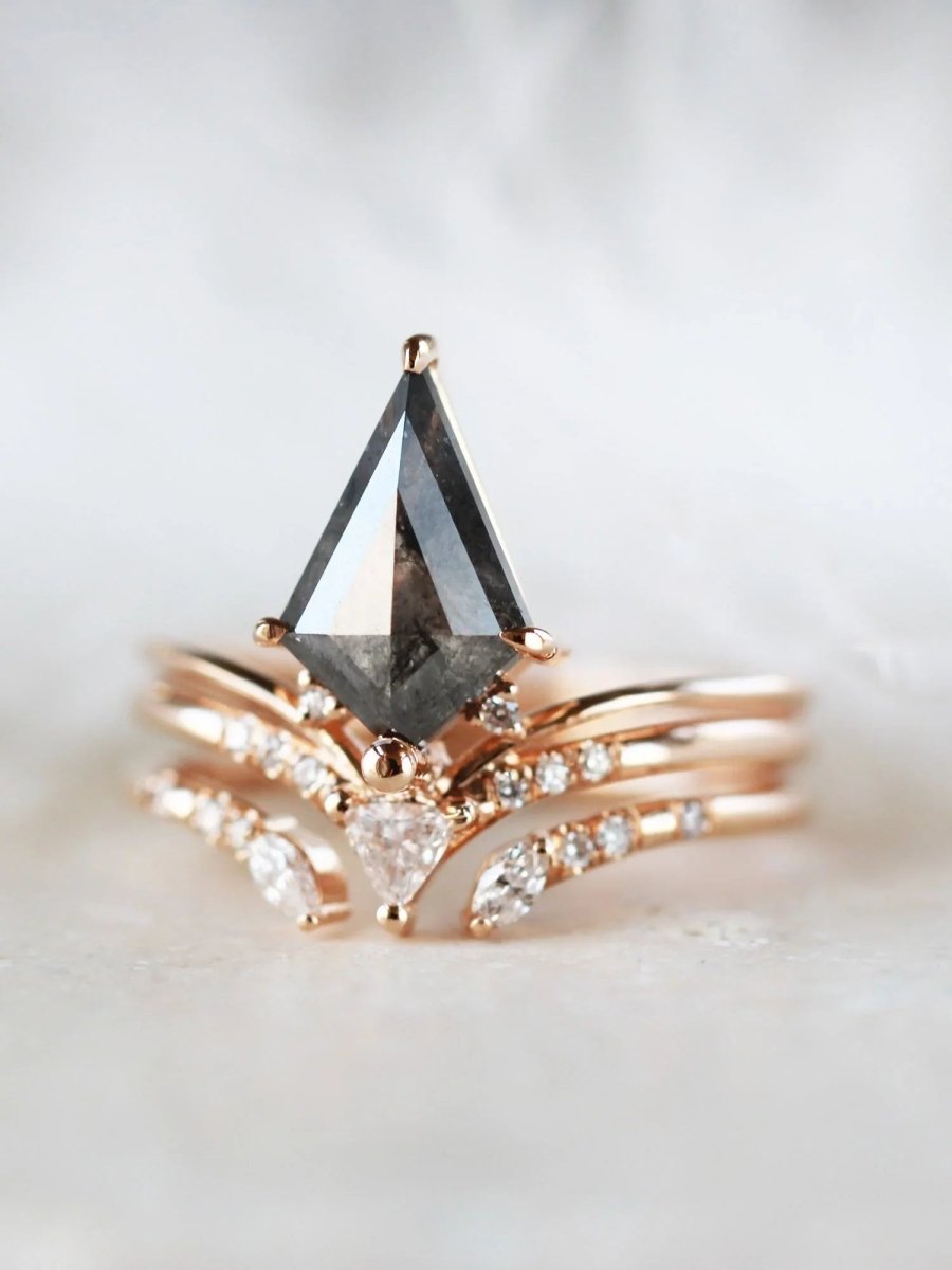 Minimalistic and art deco styled kite salt and pepper diamond engagement ring in 14k rose gold with a trilliant and round diamonds with matching band.