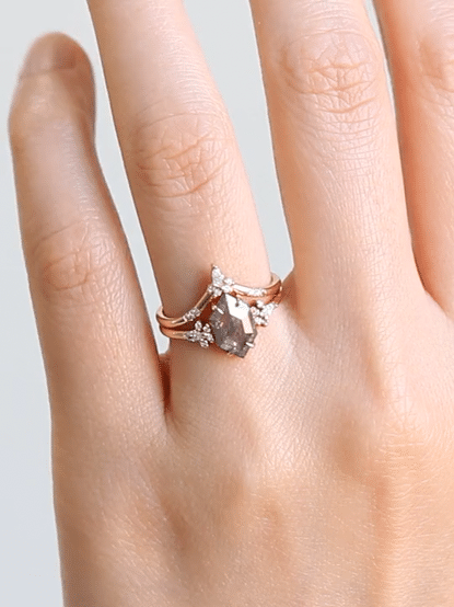 Minimalistic and art deco styled hexagon salt and pepper diamond engagement ring in 14k rose gold with a marquise and round diamonds arranged on each side.