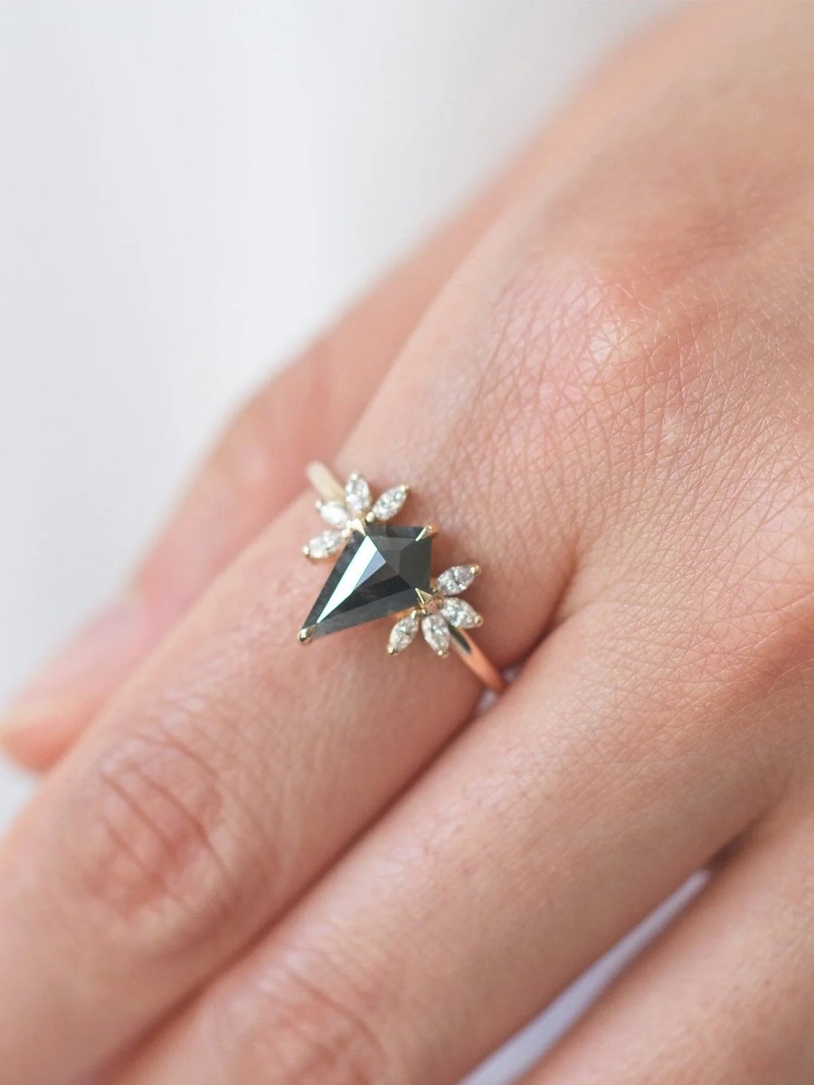 Kite salt and pepper diamond engagement ring in 14k rose gold with four marquise arrangements on each side inspired by the art deco style and minimalism on model's hand.