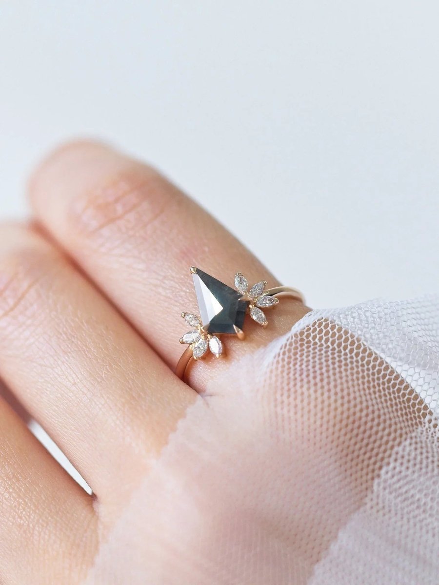 Kite salt and pepper diamond engagement ring in 14k rose gold with four marquise arrangements on each side inspired by the art deco style and minimalism on model's hand.