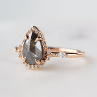 Pear-shaped salt and pepper diamond engagement ring in 14k rose gold inspired by the art deco style and minimalism. 