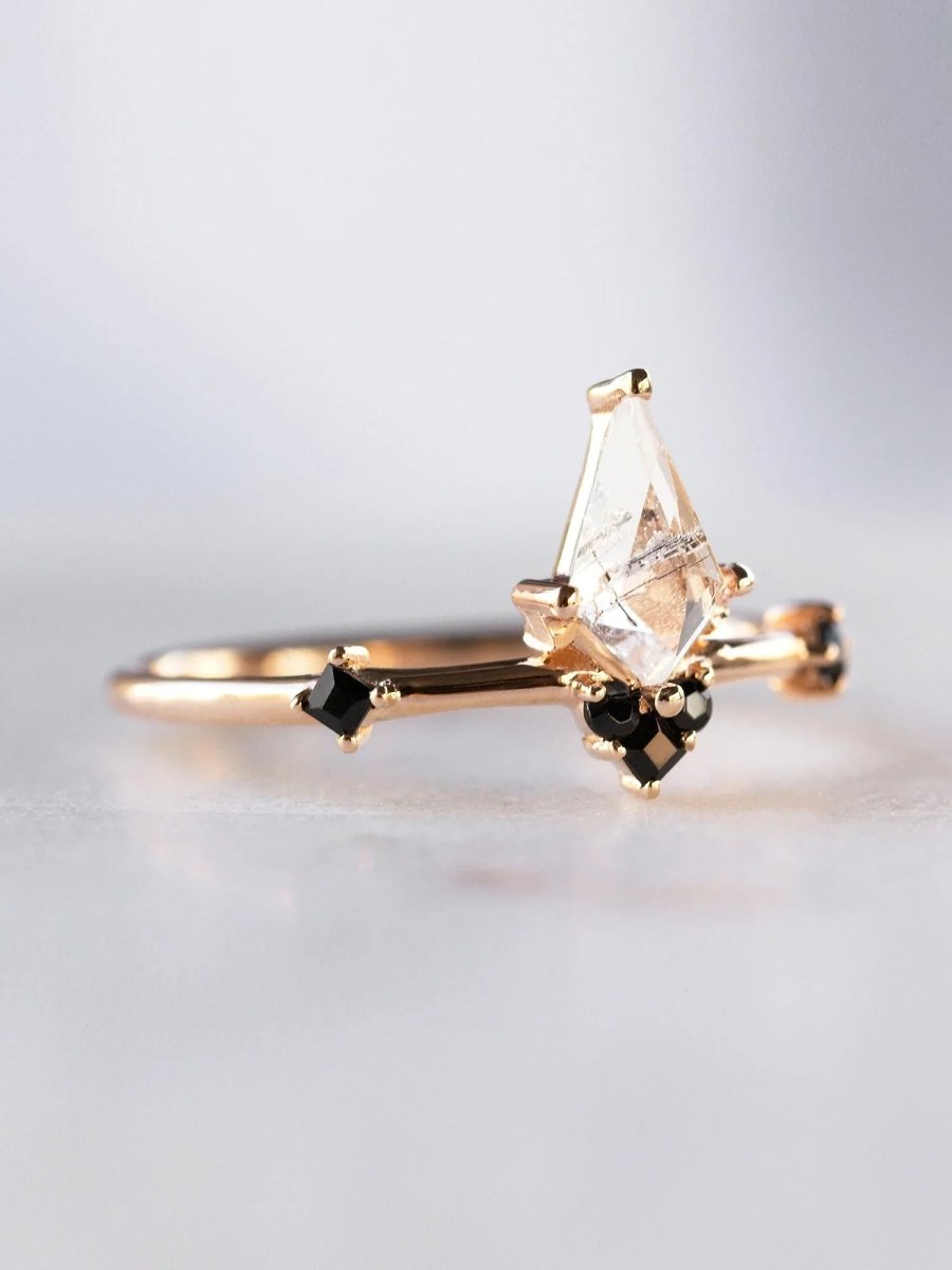 3/4 view of minimalist Art Deco ring in sunlight, showing kite tourmalinated center and onyx accents with natural sparkle