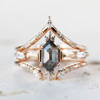 Minimalistic and art deco styled hexagon salt and pepper diamond engagement ring in 14k rose gold with round and baguette diamonds with matching bands.