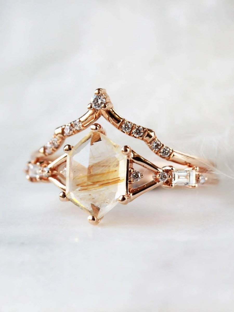 Hexagon rutilated quartz engagement ring in 14k rose gold with smaller baguette and round diamonds inspired by the art deco style and minimalism.