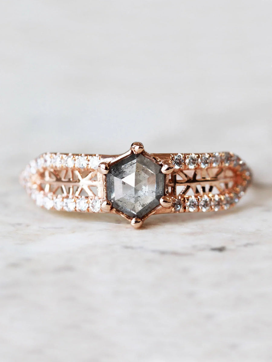 Face view of contemporary engagement ring in sunlight, highlighting the salt pepper diamond’s brilliance and the sparkle of pave melee