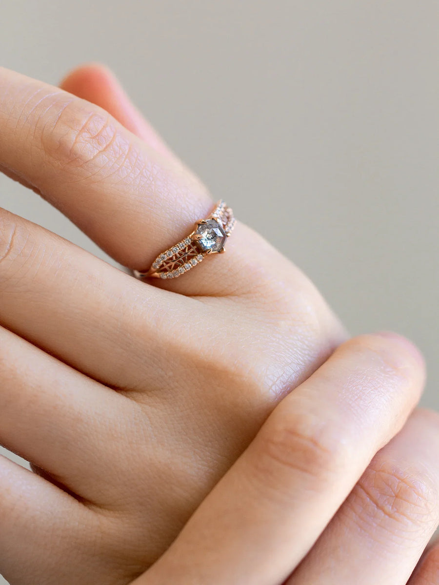 Close-up of hand gently holding another wearing contemporary engagement ring, captured in soft lighting to evoke a romantic, intimate feel