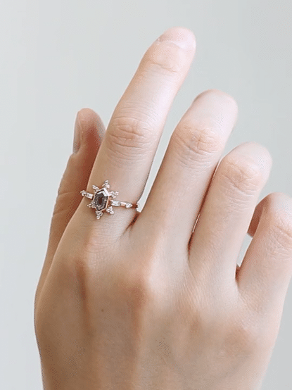 GIF of hand wearing vintage-modern rose gold Art Deco ring on index finger, slowly turning to reveal sparkle and sunburst details