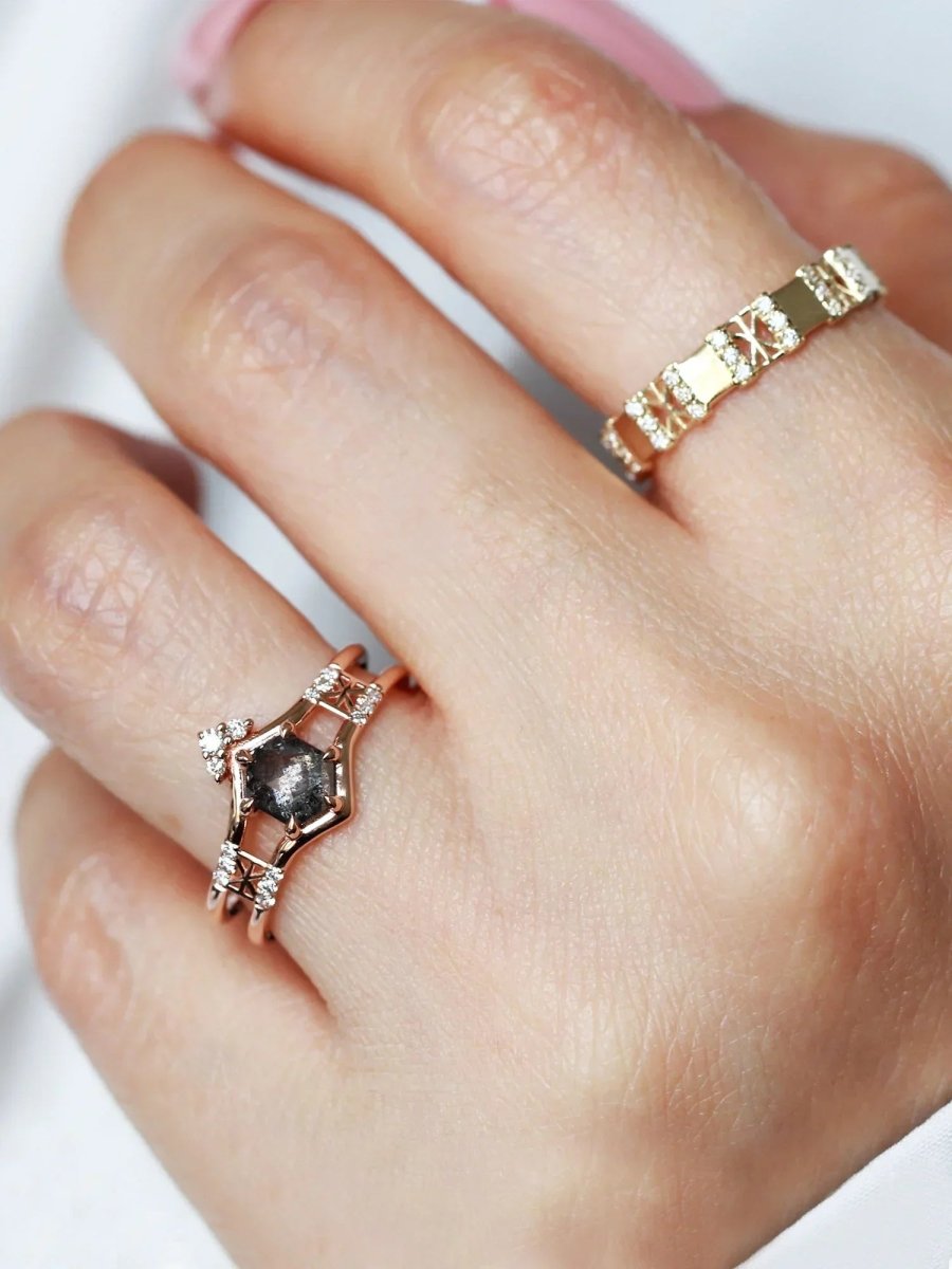 Close-up of hand wearing double-banded contemporary Art Deco chevron engagement ring with hexagon center and matching infinity band