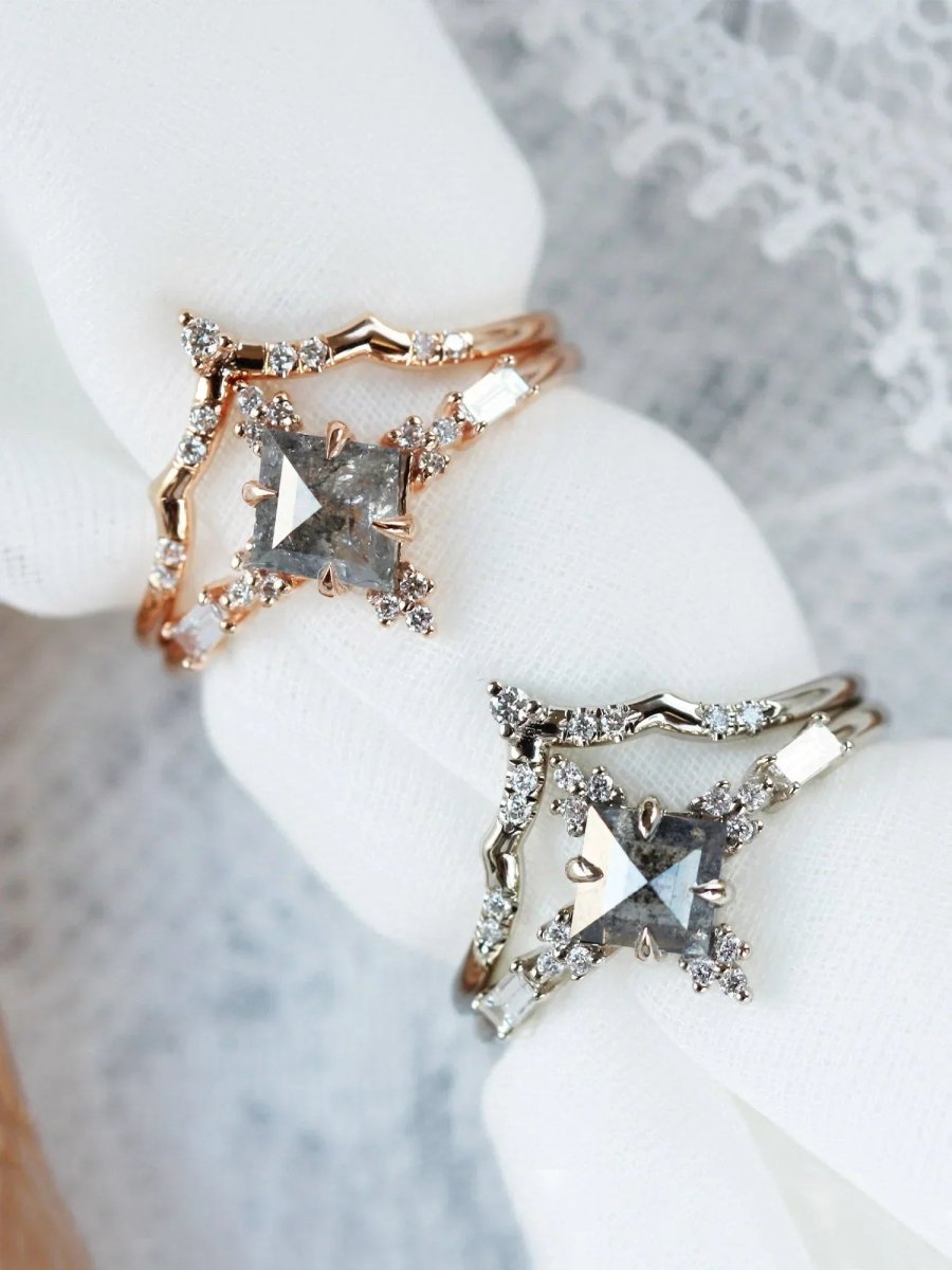 Two rose gold rings with star-shaped gemstones on a white surface.