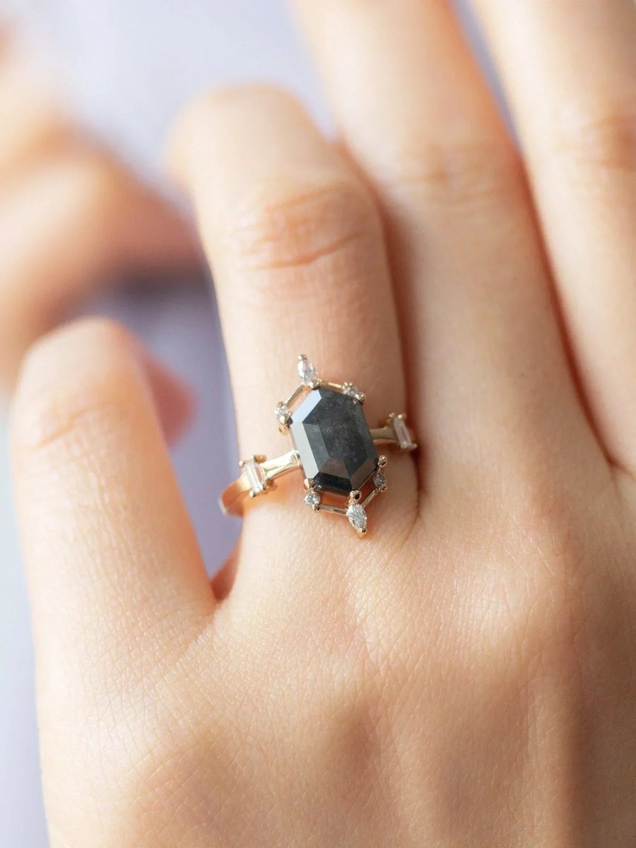 hand wearing a contemporary Art Deco ring with hexagon center stone, semi-halo detail