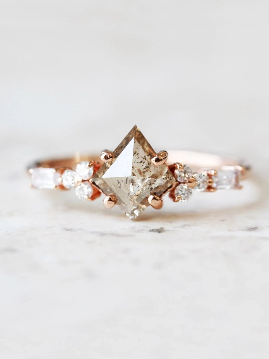 Face view of petite ring with white kite salt and pepper diamond, trefoil melee accents on shoulders, and baguette stones on band.